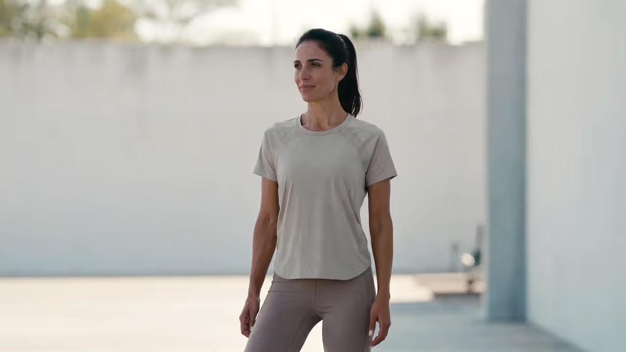 Athlete standing calmly in a gym, symbolizing balanced and smarter training approach