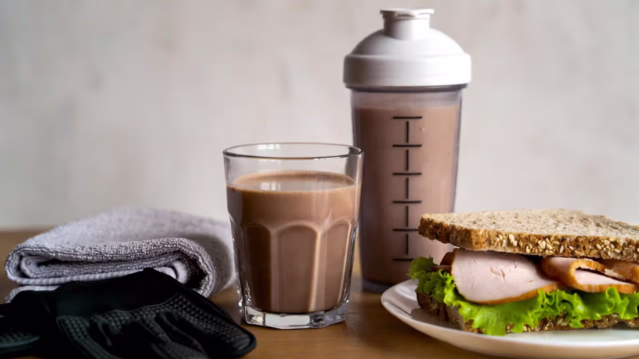Post-workout recovery foods including chocolate milk, protein shake, and whole grain turkey sandwich