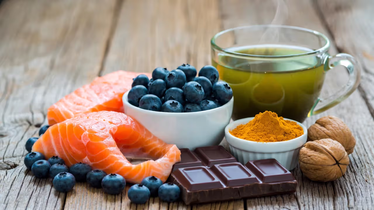 Omega-3 and polyphenol-rich foods including salmon, berries, green tea, dark chocolate, turmeric, and walnuts